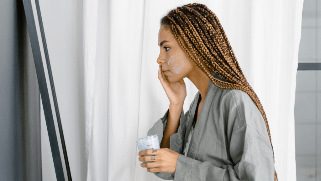 Lady putting cream on her face 