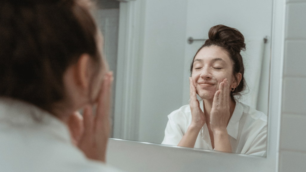 Woman applying cleanser on her face